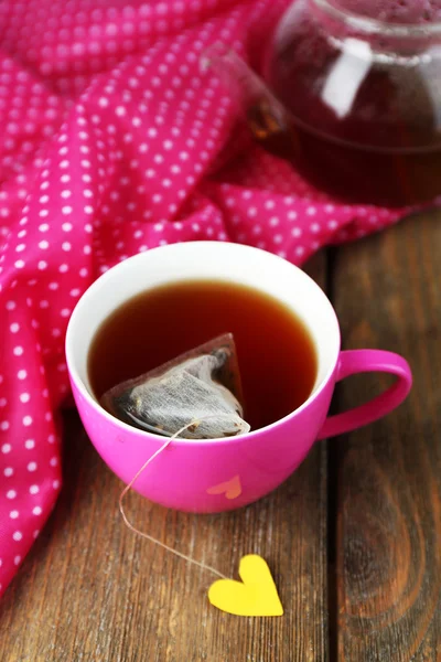 Tasse Tee, Teekanne und Teebeutel auf Holztisch in Großaufnahme — Stockfoto