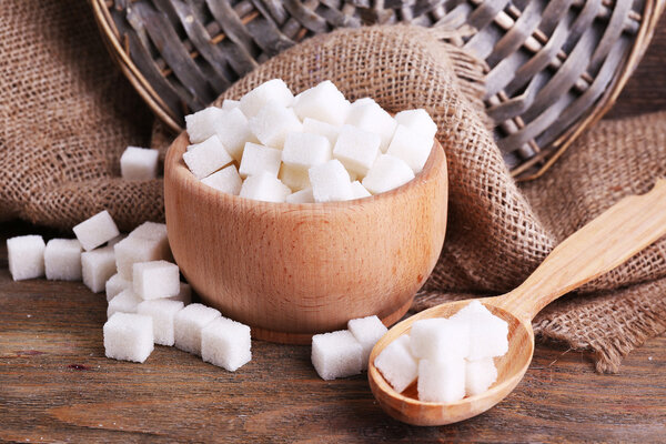 Refined sugar wooden bowl on table background