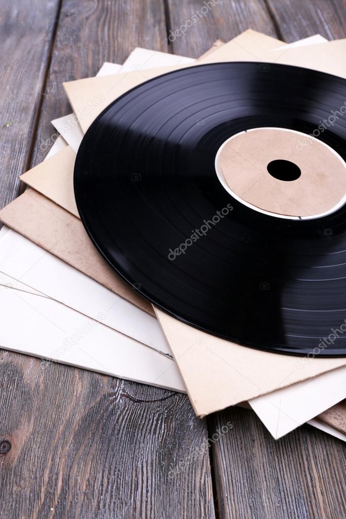 Vinyl records records and paper covers on wooden background