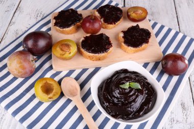 Erik reçeli, Erik reçeli ve peçete ahşap zemin üzerinde kesme tahtası üzerinde taze Erik ile ekmek dilimleri kase