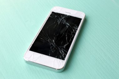 Ahşap arka planda kırık ekranlı modern cep telefonu