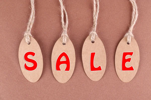 Sale tags on brown background — Stock Photo, Image