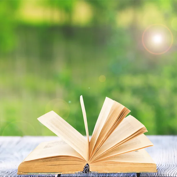 Open book on table outdoors — Stock Photo, Image