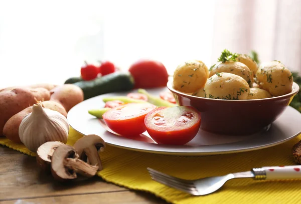 Jeunes pommes de terre bouillies avec légumes sur la table — Photo