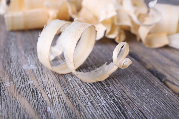 Wood shavings on grey wooden background closeup — Stock Photo, Image