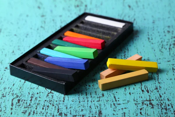 Pasteles de tiza de colores en caja sobre fondo de madera de color —  Fotos de Stock