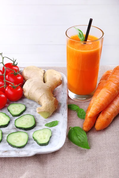 Copo de suco de cenoura fresca e legumes na mesa de madeira — Fotografia de Stock
