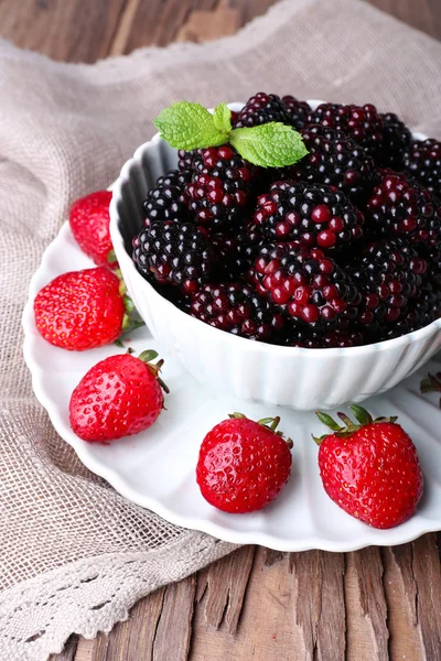 Bowl of blackberries and plate of strawberries — Stock Photo, Image