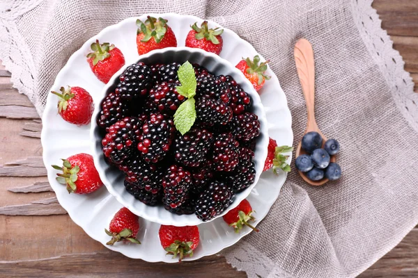 Bowl of blackberries and plate of strawberries — Stock Photo, Image