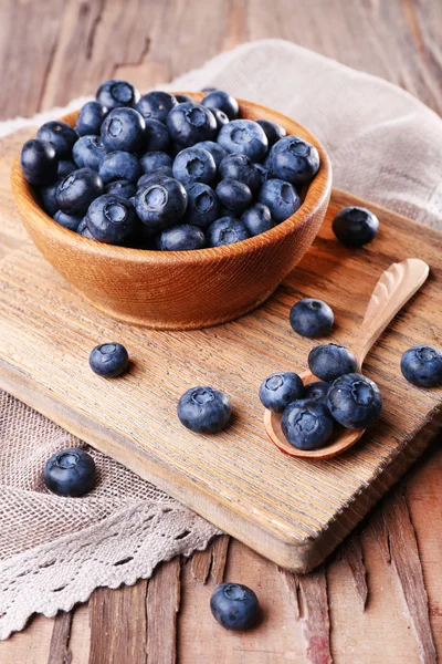 Holzschale mit Blaubeeren auf Schneidebrett — Stockfoto