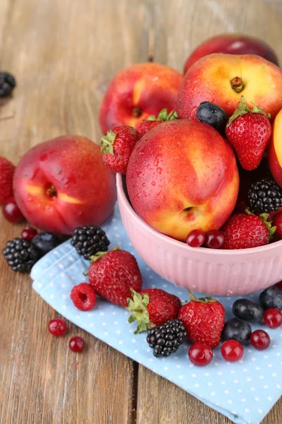 Peaches and berries in bowl on table close-up — Stock Photo, Image