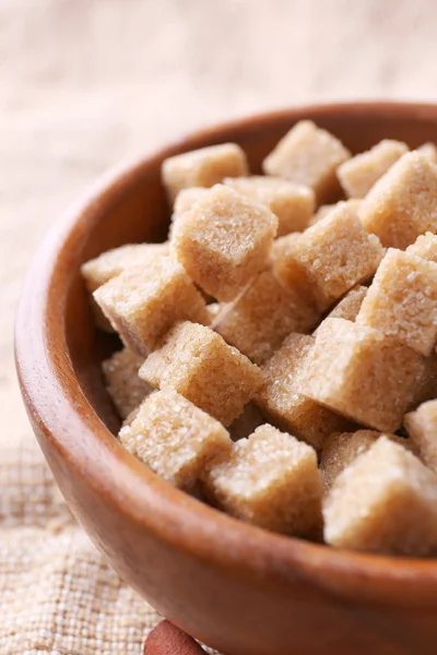 Cubes de sucre brun dans un bol sur fond de sac — Photo