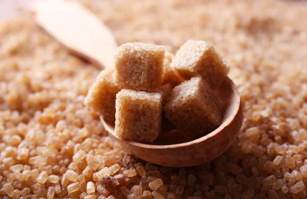 Brown sugar cubes in wooden spoon — Stock Photo, Image