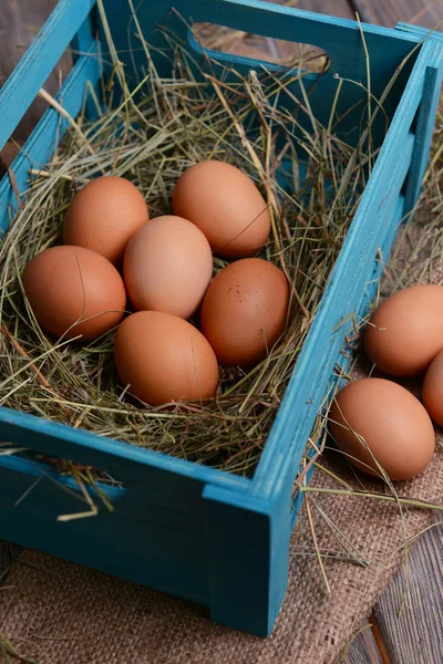 Huevos en caja de madera en primer plano de la mesa — Foto de Stock