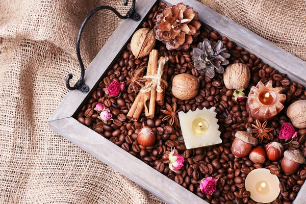 Velas en bandeja vintage con granos de café y especias, protuberancias sobre fondo de saco — Foto de Stock