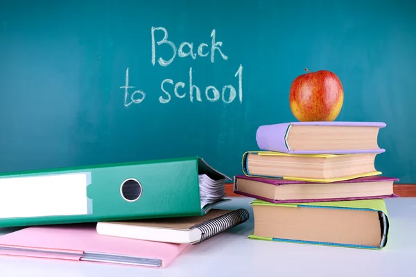 School levert op tafel op blackboard achtergrond — Stockfoto
