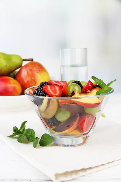 Macedonia di frutta fresca e gustosa sul tavolo, su sfondo chiaro — Foto Stock