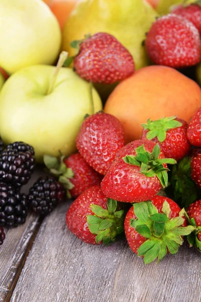 Rijp fruit en bessen op houten achtergrond — Stockfoto
