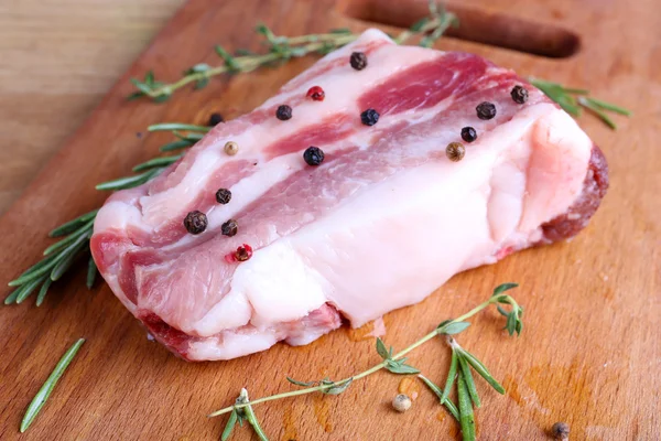 Bacon cru com especiarias na mesa de madeira — Fotografia de Stock