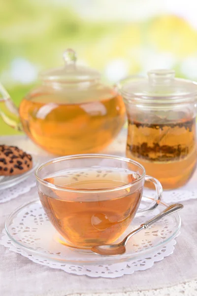 Teapot and cups of tea on table on bright background — Stock Photo, Image