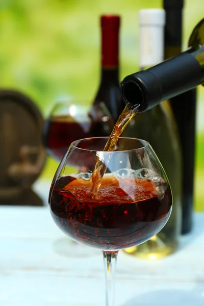 Червоне вино вливається в келих для вина, крупним планом — стокове фото