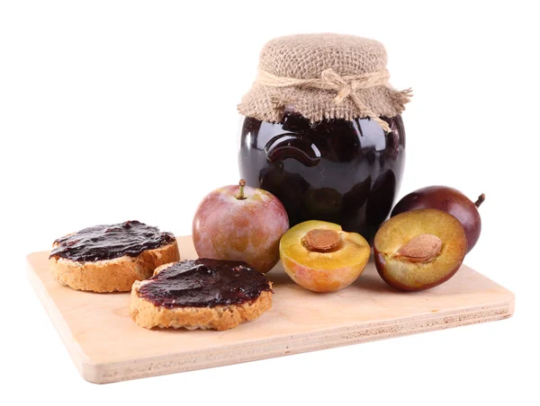Marmellata di prugne, fette di pane con marmellata di prugne e prugne fresche sul tagliere isolate su bianco — Foto Stock