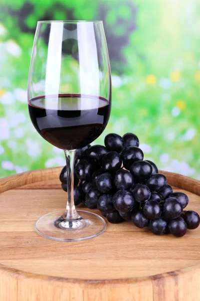 Vino saporito e uva matura su sfondo verde natura — Foto Stock