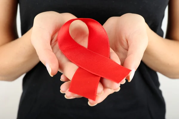 Woman in black holding red ribbon isolated on white — Stock Photo, Image