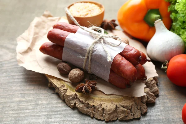 Composition de fines saucisses fumées, moutarde dans un bol et épices sur planche à découper, sur fond de bois — Photo