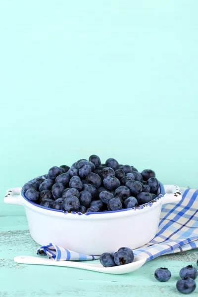 Läckra mogna blåbär i skål, på träbord — Stockfoto
