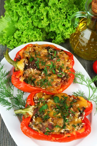 Stuffed red peppers with greens on plate on table close up — Stock Photo, Image