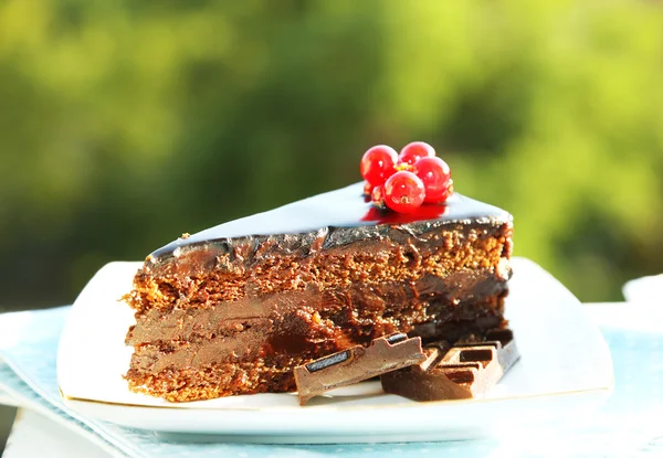 Κέικ σοκολάτας με φρέσκα μούρα σε πιάτο, στο ξύλινο τραπέζι, σε φωτεινό φόντο — Φωτογραφία Αρχείου