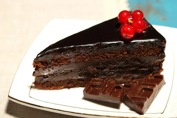 Pastel de chocolate con bayas frescas en el plato, sobre fondo de madera de color —  Fotos de Stock