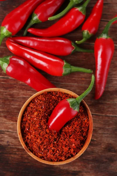 Őrölt piros chili paprika tál fából készült háttér — Stock Fotó