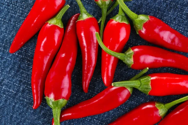 Röd hoade Chilipeppar på färg tyg bakgrund — Stockfoto