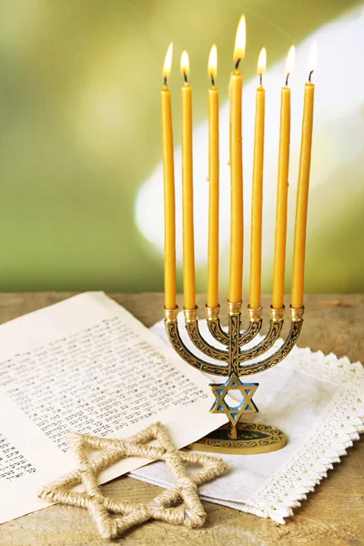 Menorah, star of David and page of Genesis book on wooden table, on bright background — Stock Photo, Image