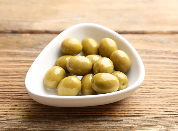 Grüne Oliven in Schüssel auf dem Tisch in Großaufnahme — Stockfoto