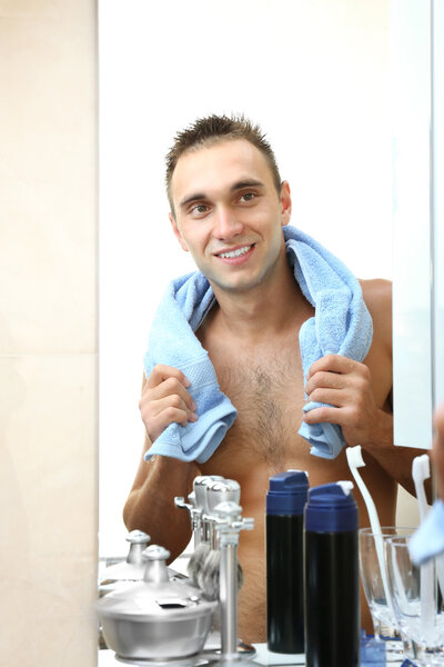 Young man shaving his beard
