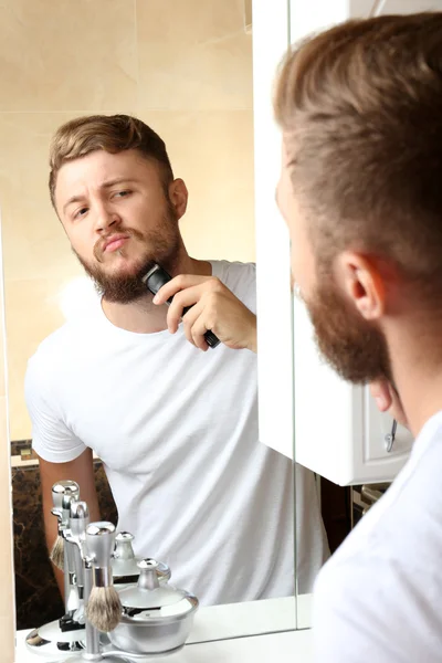 Young man shaving his beard — Stock Photo, Image