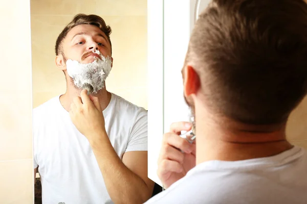 Junger Mann rasiert sich den Bart — Stockfoto