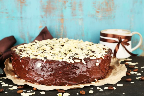 Leckerer Schokoladenkuchen mit Mandeln, auf altem Holztisch — Stockfoto