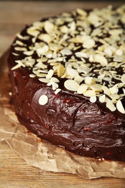 Leckerer Schokoladenkuchen mit Mandeln, auf Holztisch — Stockfoto