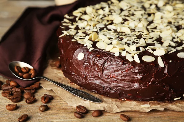 Sabroso pastel de chocolate con almendras, sobre mesa de madera —  Fotos de Stock