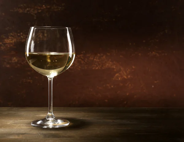 Copa de vino blanco sobre mesa de madera sobre fondo de pared de madera — Foto de Stock