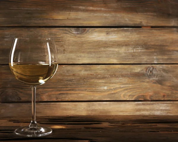 Goblet of white wine on wooden table on wooden wall background — Stock Photo, Image