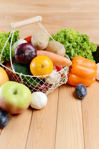 Färska ekologiska frukter och grönsaker i rotting korg på trä bakgrund — Stockfoto