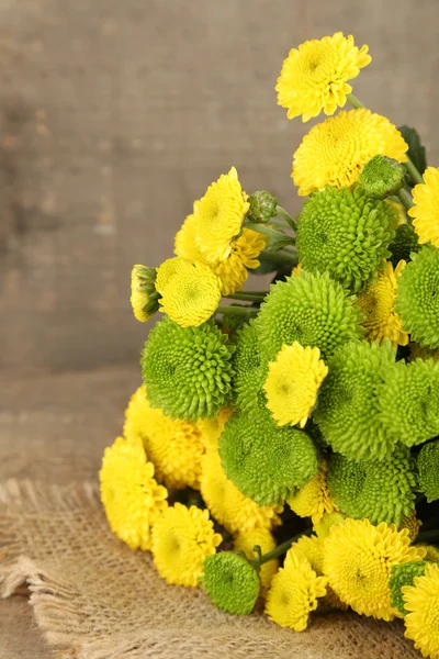 Yellow and green flowers on wooden background — Stock Photo, Image