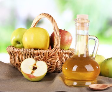 cam şişe ve doğa zemin üzerine ahşap masa üzerinde olgunlaşmış taze elma, elma sirkesi