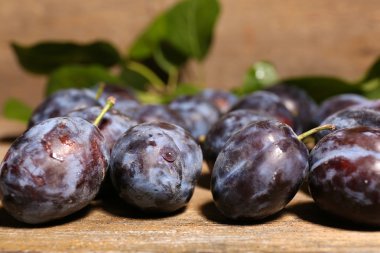 Olgun tatlı Erik yapraklarla ahşap tablo