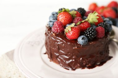 ahşap masa üzerinde farklı meyveleri lezzetli çikolatalı kek